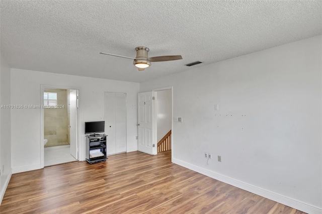 unfurnished living room featuring wood-type flooring, a textured ceiling, and ceiling fan