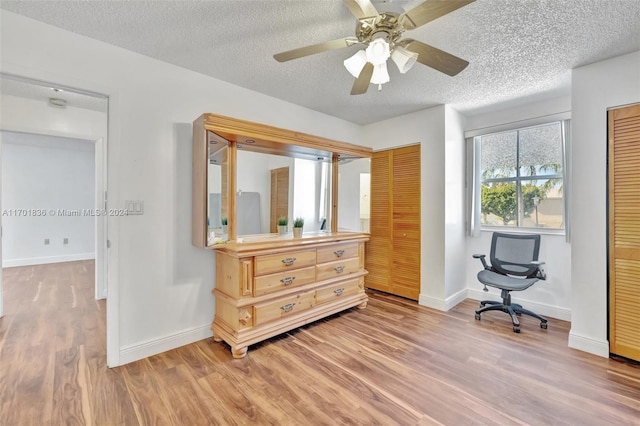 interior space featuring ceiling fan, wood-type flooring, and a textured ceiling