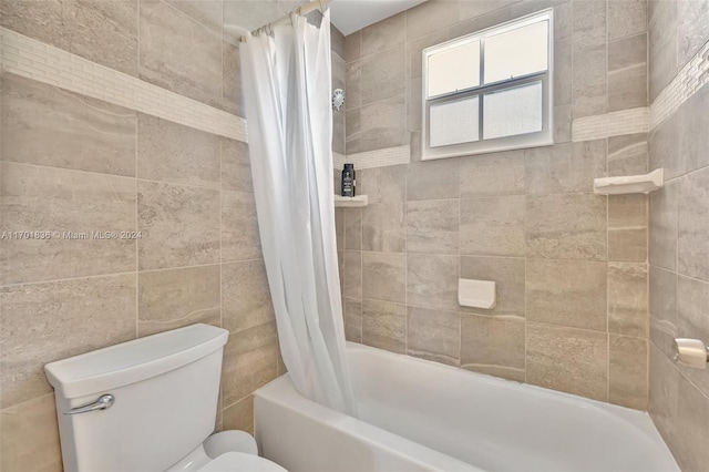 bathroom with shower / bath combo, toilet, and tile walls