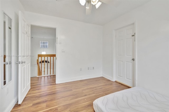 bedroom with ceiling fan, a textured ceiling, and light hardwood / wood-style flooring