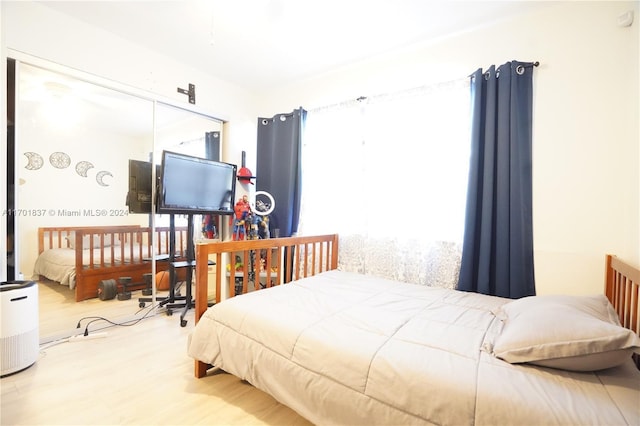 bedroom with hardwood / wood-style floors and multiple windows