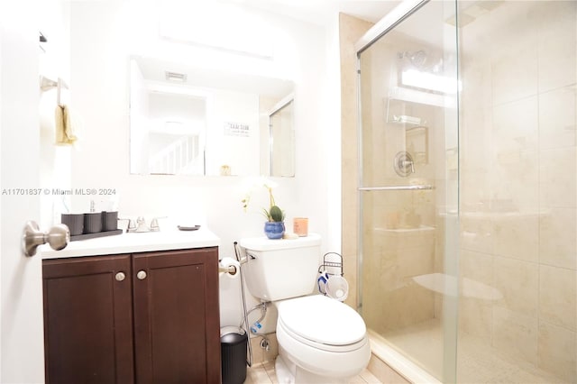 bathroom featuring vanity, an enclosed shower, and toilet