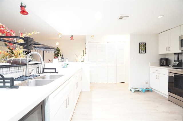 kitchen featuring sink, white cabinetry, and stainless steel appliances