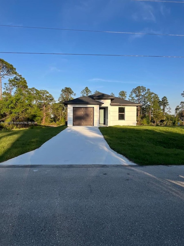 view of front facade featuring a front yard, driveway, and an attached garage