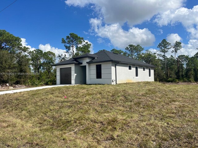 exterior space featuring an attached garage, driveway, and a lawn