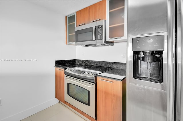 kitchen featuring dark stone countertops and appliances with stainless steel finishes