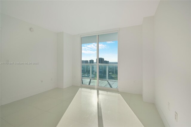 empty room with light tile patterned floors and expansive windows