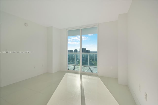 spare room featuring light tile patterned floors and a wall of windows