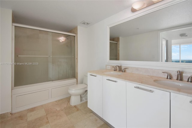 full bathroom with vanity, shower / bath combination with glass door, and toilet