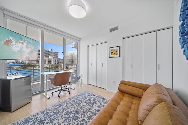 home office with light hardwood / wood-style flooring