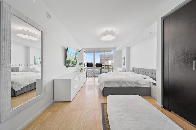 1445 16th St Unit 602, Miami Beach, FL 33139 - bedroom featuring light wood-style floors, a wall of windows, and baseboards