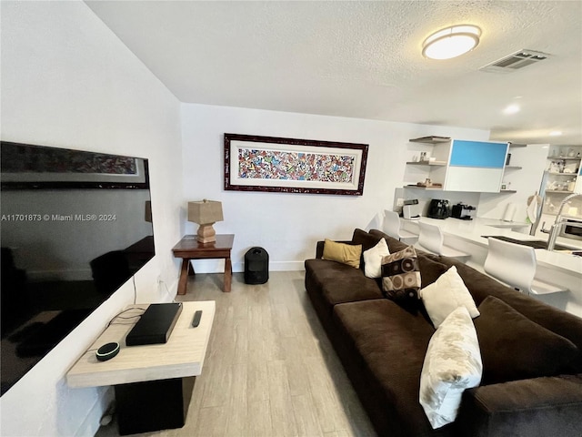 living room featuring a textured ceiling and light hardwood / wood-style flooring