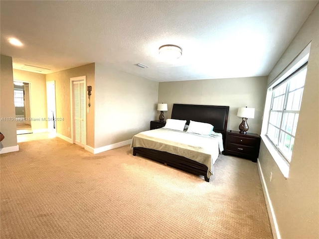 carpeted bedroom featuring a textured ceiling