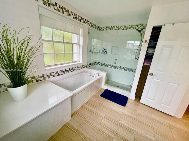 bathroom featuring separate shower and tub and tile walls