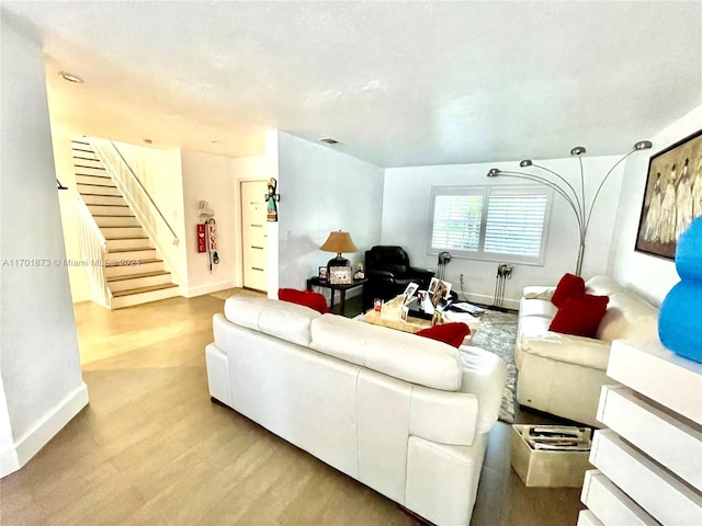 living room with light hardwood / wood-style flooring and a textured ceiling