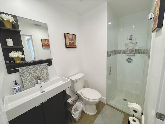 bathroom with vanity, hardwood / wood-style flooring, toilet, and walk in shower