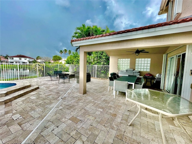 view of patio featuring ceiling fan and a water view