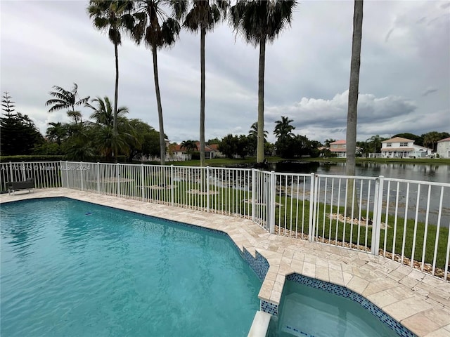 view of swimming pool featuring a patio and a water view