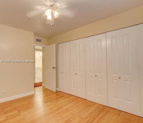 unfurnished bedroom featuring light wood-type flooring, a closet, and ceiling fan