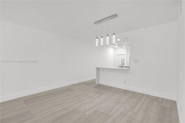 unfurnished dining area featuring sink and light hardwood / wood-style flooring