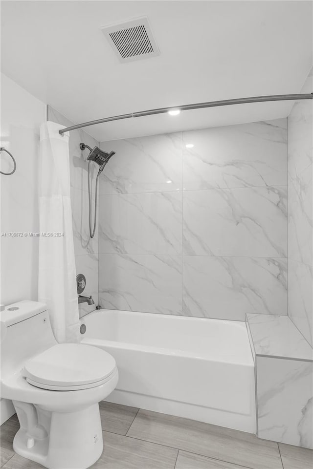 bathroom with shower / bathtub combination with curtain and toilet