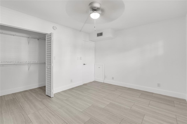 unfurnished bedroom with ceiling fan and a closet