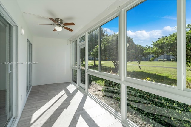 unfurnished sunroom featuring ceiling fan