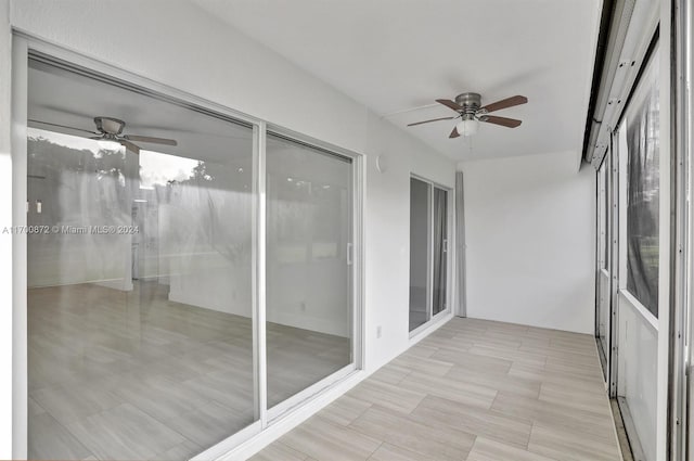 unfurnished sunroom featuring ceiling fan