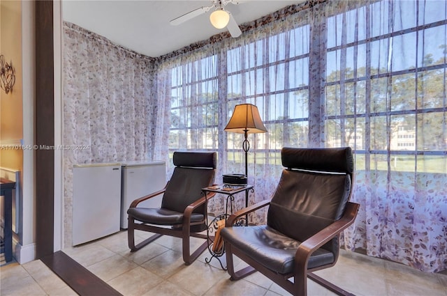 living area featuring light tile patterned floors and ceiling fan