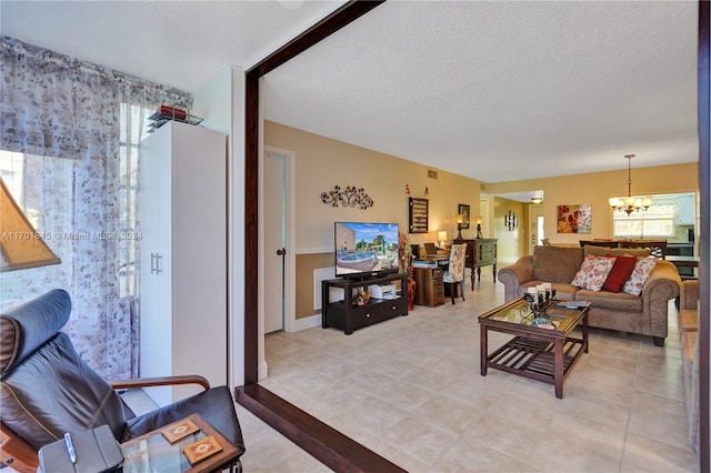 living room featuring a textured ceiling and a chandelier