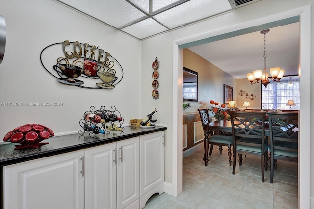 tiled dining area featuring a chandelier