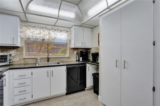 kitchen with sink, light tile patterned floors, black dishwasher, a paneled ceiling, and white cabinets