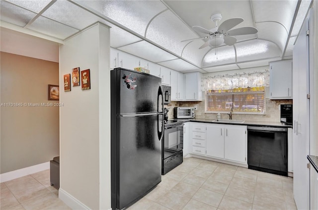 kitchen featuring tasteful backsplash, a drop ceiling, sink, black appliances, and white cabinetry