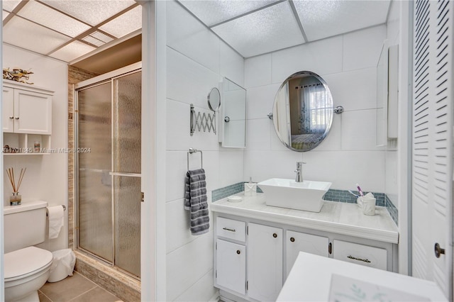 bathroom with tile patterned flooring, vanity, an enclosed shower, and toilet