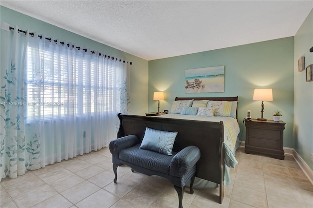 bedroom featuring light tile patterned floors and a textured ceiling