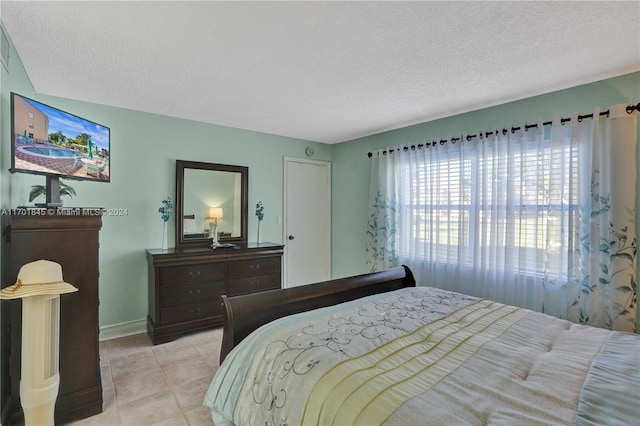 bedroom with light tile patterned floors and a textured ceiling