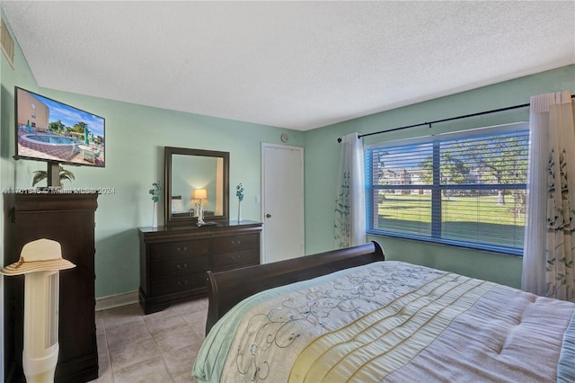 bedroom with light tile patterned floors and a textured ceiling