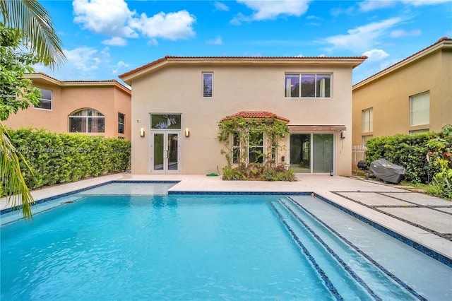 view of swimming pool featuring a grill and french doors