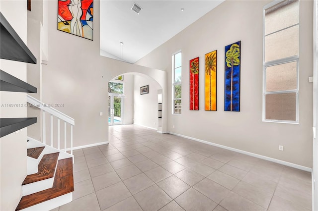 tiled entryway featuring high vaulted ceiling