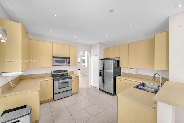 kitchen with sink, light tile patterned floors, stainless steel appliances, and light brown cabinetry