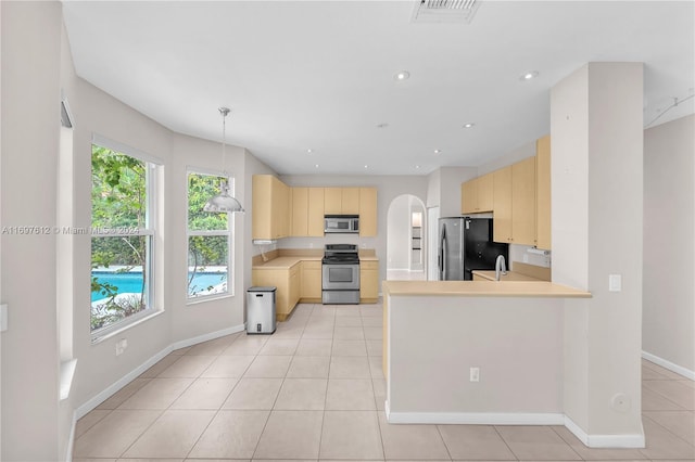 kitchen with pendant lighting, kitchen peninsula, stainless steel appliances, and light brown cabinetry