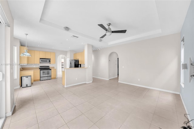 unfurnished living room featuring ceiling fan, light tile patterned floors, and a tray ceiling