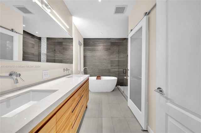 bathroom featuring tile patterned flooring, vanity, independent shower and bath, and tile walls