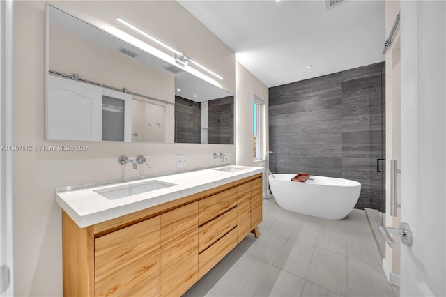 bathroom with tile patterned floors, vanity, a bath, and tile walls