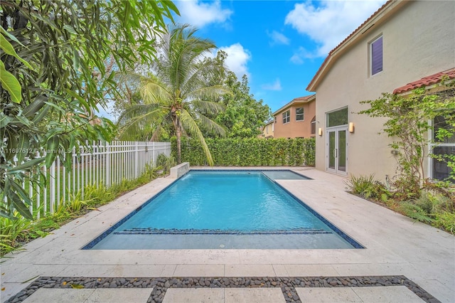 view of swimming pool featuring french doors