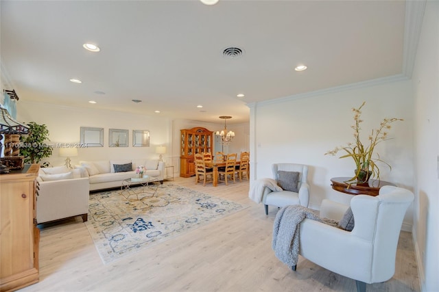 living room with light wood-type flooring, an inviting chandelier, and ornamental molding