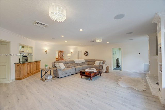 living room with a notable chandelier, crown molding, and light hardwood / wood-style flooring