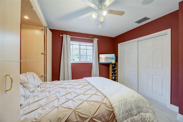 bedroom with ceiling fan, a closet, and a textured ceiling