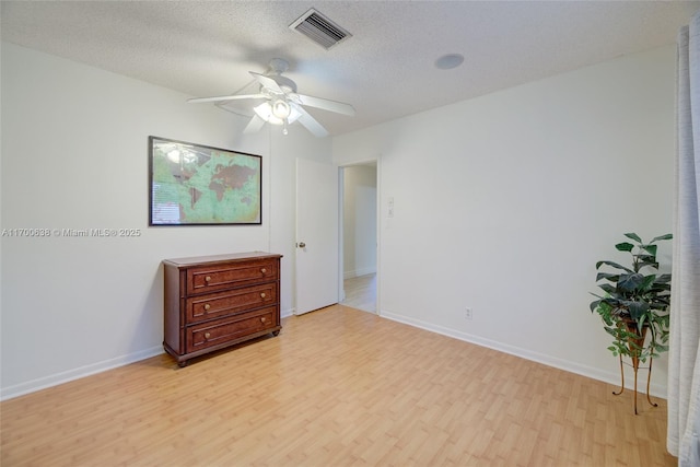 unfurnished bedroom featuring ceiling fan, light hardwood / wood-style floors, a textured ceiling, and a closet