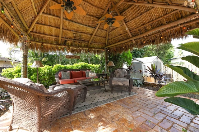 view of patio / terrace with a gazebo, an outdoor living space, and a storage shed